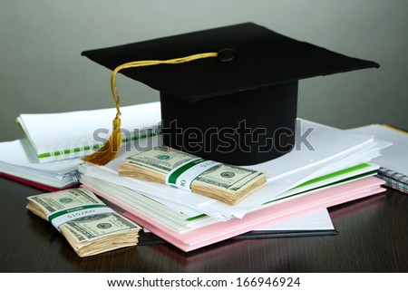 Money for graduation or training on wooden table on grey background