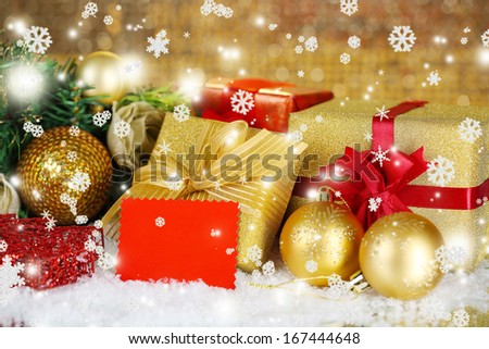 Gift boxes with blank label and Christmas decorations on table on bright background