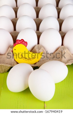 Eggs in paper tray on green wooden table close-up