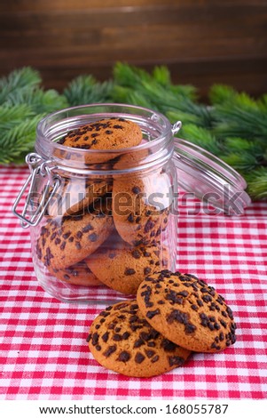 Delicious Christmas cookies in jar on table on wooden background