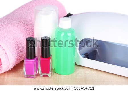 Lamp for nails and accessories for manicure on table on bright background