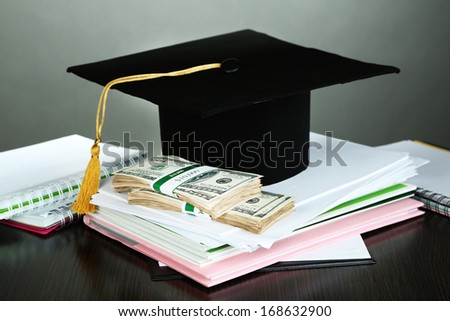Money for graduation or training on wooden table on grey background