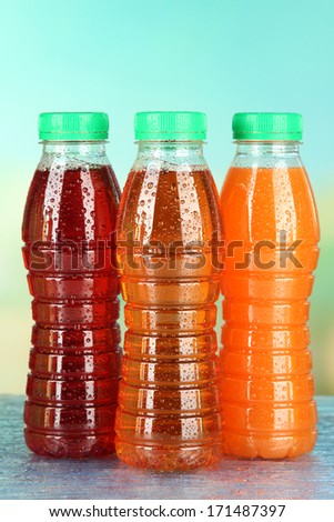 Assortment of bottles with tasty fruit juices on bright background
