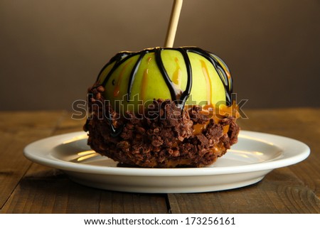Candied apple on stick on wooden table