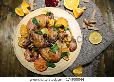 Homemade fried chicken drumsticks with vegetables on wooden tray, on wooden background