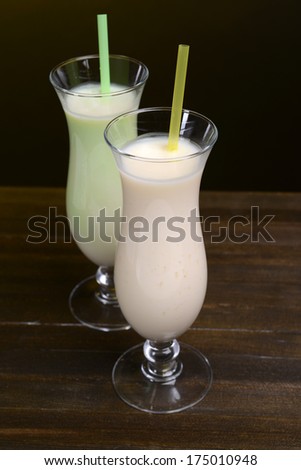 Milk shakes on table on black background