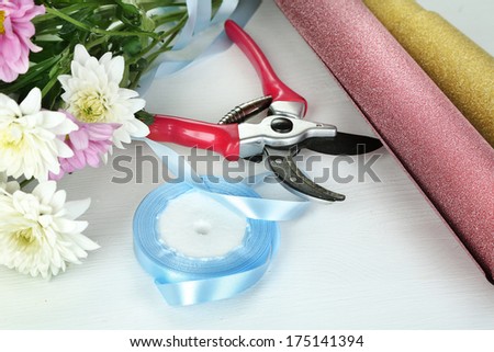 Garden secateurs and flowers isolated on white