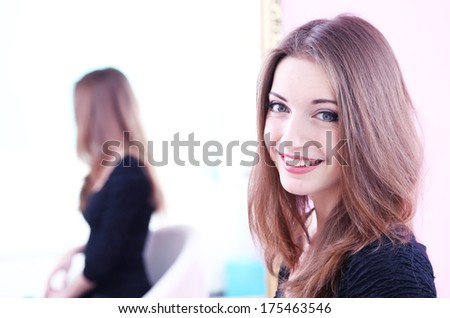 Young beautiful woman sitting front of mirror in room