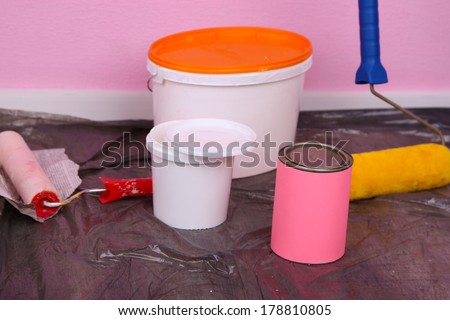 Buckets with paint and ladder on wall background. Conceptual photo of repairing works in  room