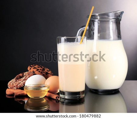 Eggnog with milk and eggs on grey background
