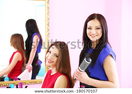 Beautiful woman hairdresser do hairstyle girl in beauty salon