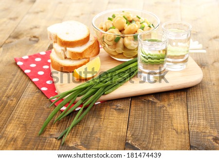 Composition with glasses of vodka and marinated  mushrooms on wooden background
