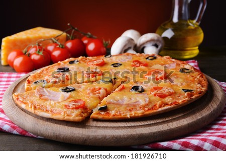 Tasty pizza on table on dark red background