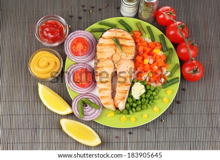 Tasty grilled salmon with vegetables, on bamboo mat
