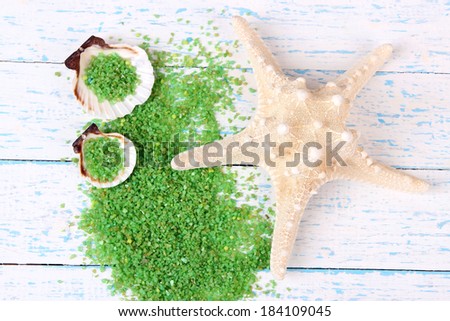 Sea salt crystals with sea shells, star fish  on color wooden background
