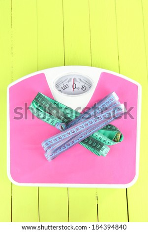 Measuring tape and scales close-up on wooden table