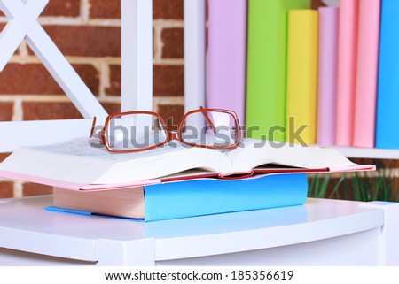 Composition with glasses and books, on chair, on cabinet and wall background