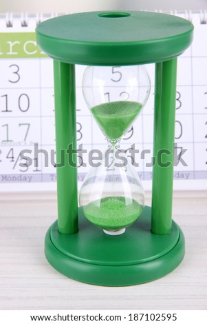 Hourglass and calendar close-up