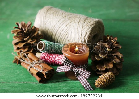 Composition with natural bump, candle, thread, cinnamon sticks on wooden background