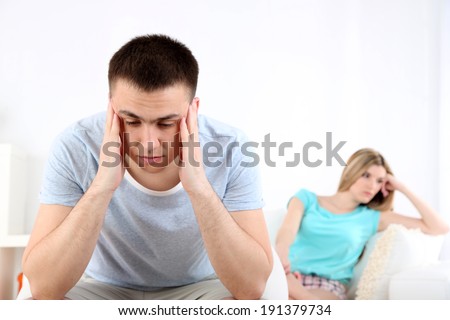 Portrait of young man and woman  conflict sitting on sofa argue unhappy, on home interior background