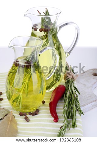 Essential Oil with rosemary in glass jug, on cutting boards, isolated on white