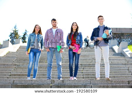 Happy students on stairs in park