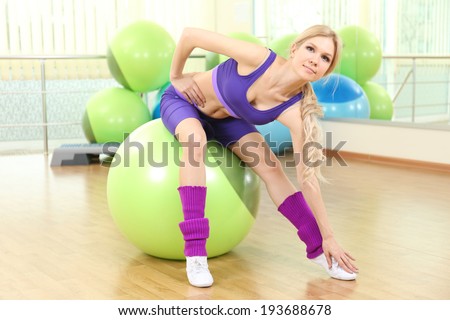 Young woman training with gymnastic ball in gym