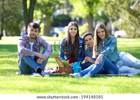 Happy friends on picnic in park