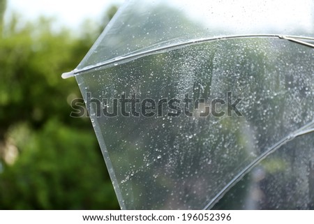 Wet transparent umbrella on natural background