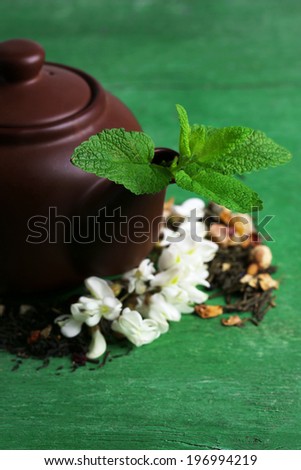 Herbal natural floral tea infusion with dry flowers and herbs ingredients, on color wooden background
