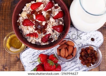 Healthy cereal with milk and strawberry on wooden table