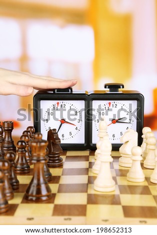 Hand pushing chess clock, close up