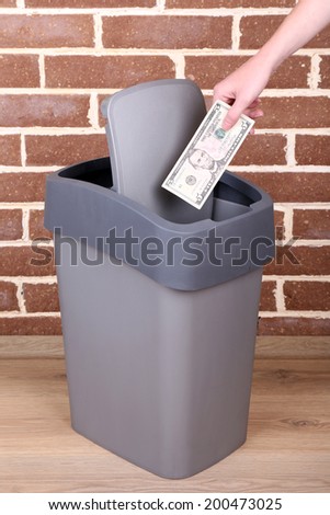 Throwing away your money on brick wall background