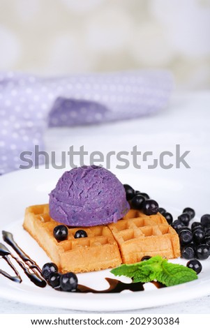 Tasty belgian waffles with ice cream on wooden table