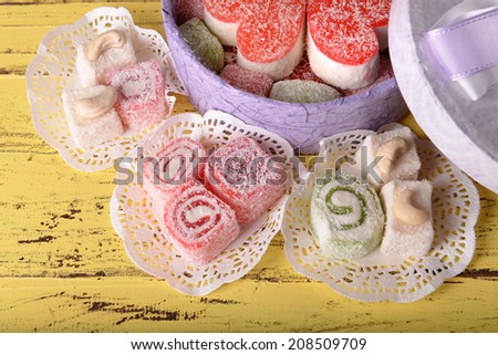 Present box with sweets on wooden background