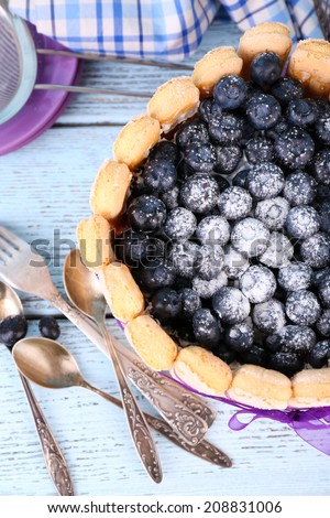 Tasty cake Charlotte with blueberries on blue wooden table