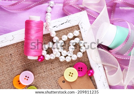 Scrapbooking craft materials and wooden frame with sackcloth inside on color wooden background