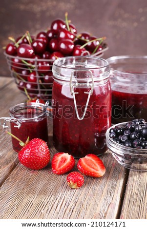 Berries jam in glass jar on table, close-up