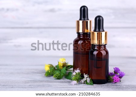 Essential oil with different medicine plants, on wooden background