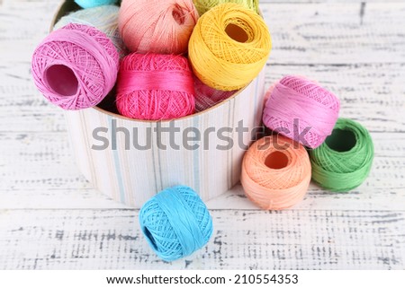 Clews of thread for hook knitting in box on wooden background