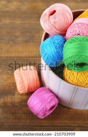 Clews for hook knitting in a box on wooden background