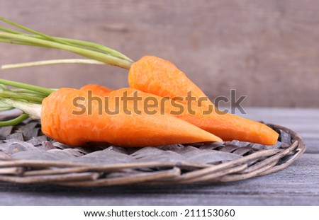 Carrots on round wooden mat on wooden table