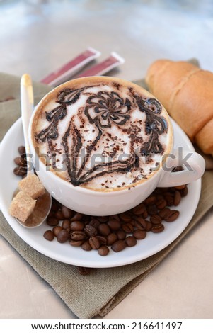 Cup of coffee with cute drawing on table, close up