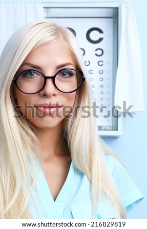 Medicine and vision concept - woman with eye chart