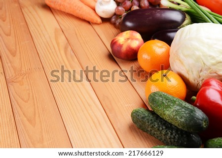 Fresh organic fruits and vegetables on wooden background