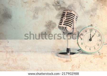 Vintage microphone and alarm clock on table