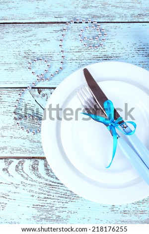 White plates, fork, knife, napkin and Christmas decoration on wooden background