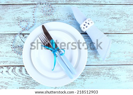 White plates, fork, knife, napkin and Christmas decoration on wooden background