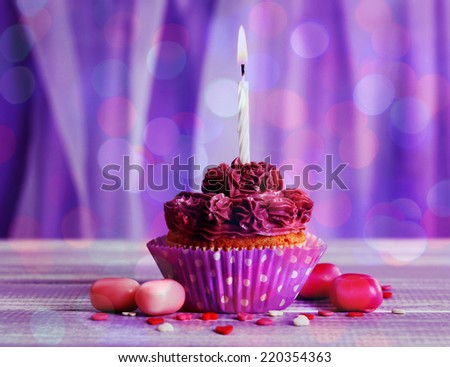 Tasty cupcake on bright purple background