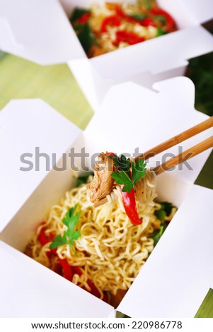 Chinese noodles and sticks in takeaway boxes closeup